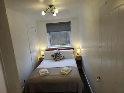 a small bedroom with a bed with two towels on it at Seafield Crt, North Shore Beach in Horse Isle