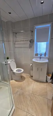 a bathroom with a toilet and a sink and a window at Malina at The Green in Glasgow