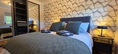 a bedroom with a large bed with blue pillows at Malina at The Green in Glasgow