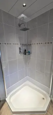 a bathroom with a shower with a white tub at Malina at The Green in Glasgow