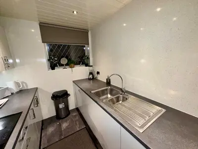 a small kitchen with a sink and a window at Likewise Modern Two bedrooms Home for 4 in Glasgow Area in Pollokshaws
