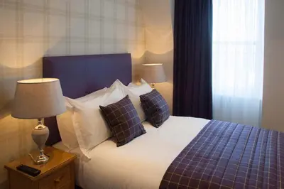 a bedroom with a bed with two pillows on it at Braid Apartments by Mansley in Edinburgh