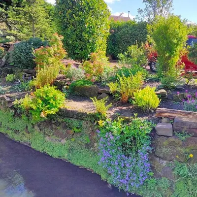 a garden with many different flowers and plants at The Old Smiddy Cottage and Apartment in Balloch