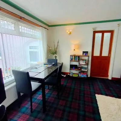 a dining room with a table with a laptop on it at The Old Smiddy Cottage and Apartment in Balloch