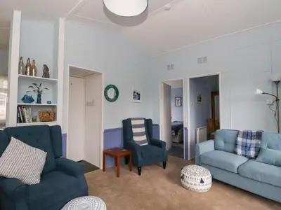 a living room with two blue chairs and a couch at Scarba in Oban