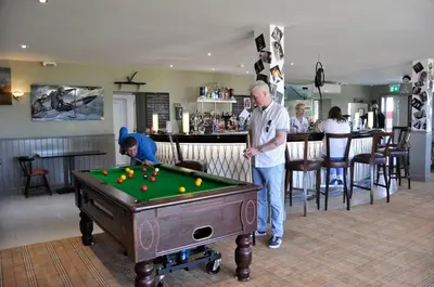 an older man standing next to a pool table at 20 Chestnut Grove in Stranraer