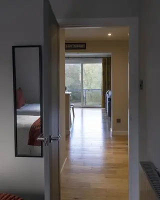 a hallway with a mirror and a bedroom with a bed at Park View apartment, Gleneagles Village, Auchterarder in Auchterarder