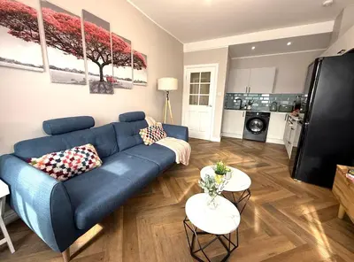 a living room with a blue couch and two tables at Modern 3-Bed Flat Prime Falkirk Location in Falkirk