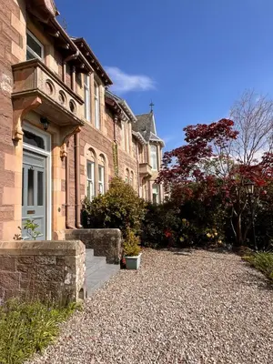 a house with a gravel driveway in front of it at Dungora House in Crieff