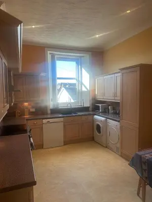 a kitchen with a window and a washing machine at Crawford House in Largs