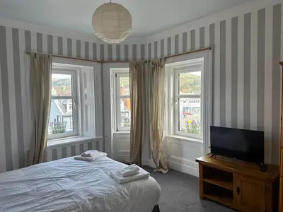 a bedroom with a bed and a flat screen tv at Crawford House in Largs