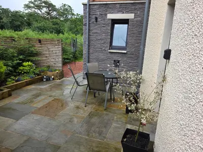 a patio with a table and chairs next to a building at Balnakeil house