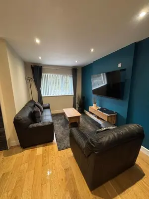 a living room with two leather couches and a flat screen tv at Balnakeil house