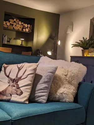 a couch with two pillows with a deer on it at Ashdale Cottage with Sauna, Plunge Pool, Games Room, Kit Drying Room in Isle of Arran