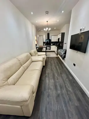 a living room with a white couch and a television at Fantastic 1 Bed in Heart of Edinburgh in Edinburgh
