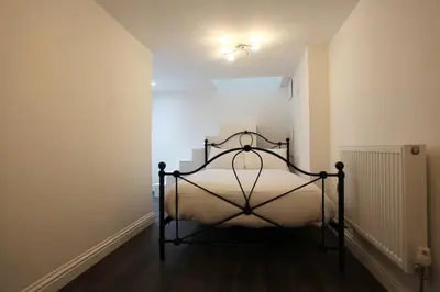 a bedroom with a bed in a white room at Fantastic 1 Bed in Heart of Edinburgh in Edinburgh