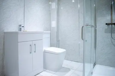 a bathroom with a toilet and a glass shower at Fantastic 1 Bed in Heart of Edinburgh in Edinburgh