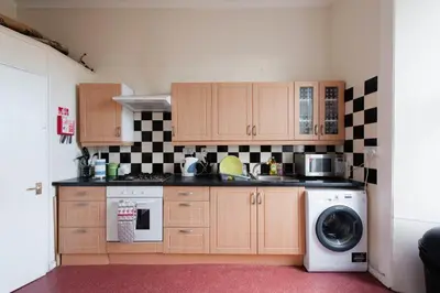 a kitchen with a washing machine and a washer at Edinburgh Central Lauriston Large Apartment in Edinburgh