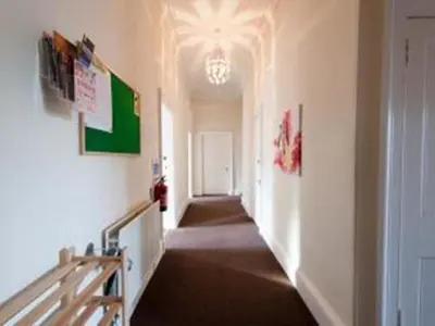a hallway with a long hallway with a chandelier at Edinburgh Central Lauriston Large Apartment in Edinburgh