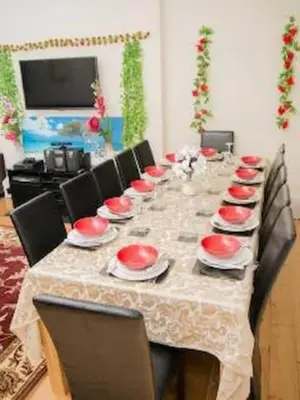a long table with red bowls and plates on it at Edinburgh Central Lauriston Large Apartment in Edinburgh
