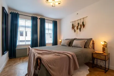 a bedroom with a large bed with blue curtains at Modern 2-Bed Apt, Private Parking, Ayr Town Centre in Ayr