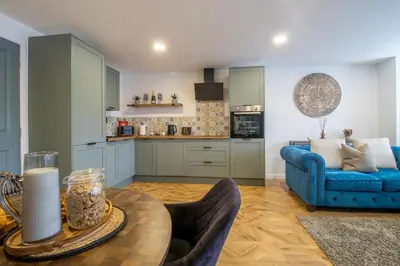 a living room with a blue couch and a table at Modern 2-Bed Apt, Private Parking, Ayr Town Centre in Ayr
