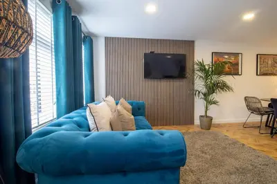 a blue couch in a living room with a television at Modern 2-Bed Apt, Private Parking, Ayr Town Centre in Ayr