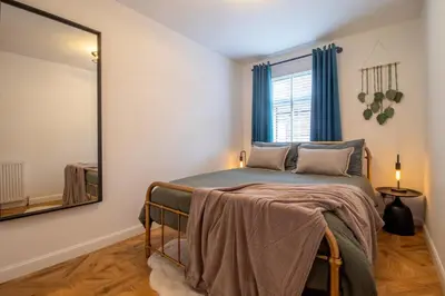 a bedroom with a bed and a mirror at Modern 2-Bed Apt, Private Parking, Ayr Town Centre in Ayr