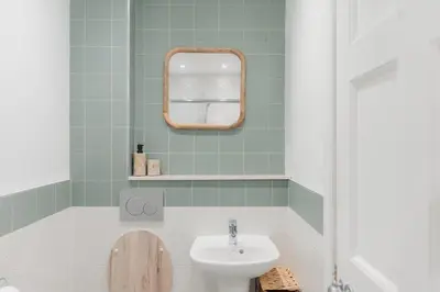 a bathroom with a sink and a toilet and a mirror at Charming Central Mews Home with Secure Parking in Edinburgh