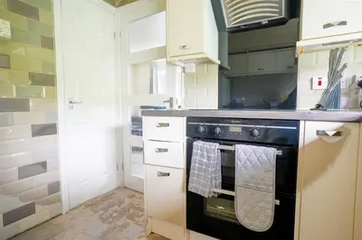 a kitchen with a stove with a towel on the oven at Arranview Retreat in Airdrie