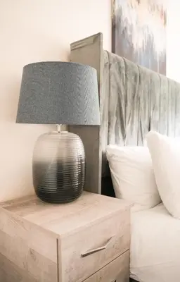 a lamp sitting on a night stand next to a bed at Arranview Retreat in Airdrie