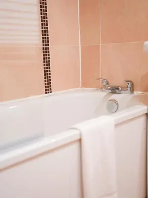 a bathroom with a white bath tub with a sink at Arranview Retreat in Airdrie