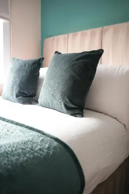 a bed with two pillows on top of it at Beechgrove House in Livingston