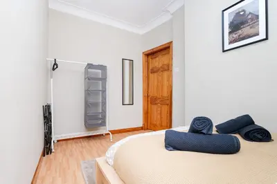 a bedroom with a bed with blue pillows on it at 2Bed Upper Cottage-Street Parking-by Holiday Homes in Falkirk