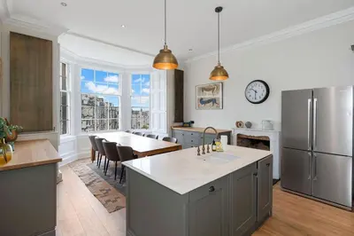 a large kitchen with a table and a refrigerator at GuestReady - Elegant Edinburgh Retreat in Edinburgh