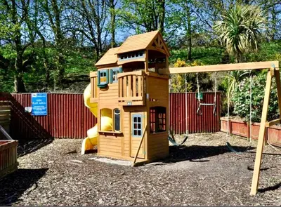 a small wooden play house with a slide at Loch View 30 in Stranraer
