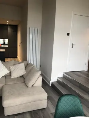 a living room with a couch and a stair case at Charming West End Flat in Edinburgh