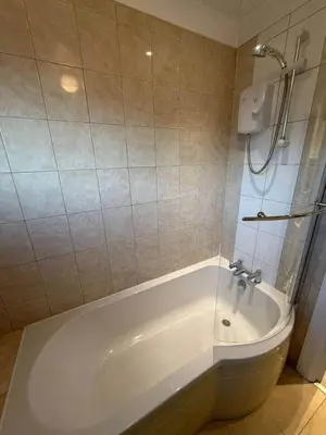 a white bath tub in a bathroom with a shower at Modern 2BR Sleeps 4 Central Scotland with Parking in Banknock