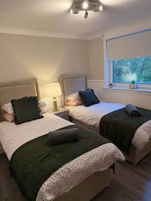 a bedroom with two beds and a window at Modern 2BR Sleeps 4 Central Scotland with Parking in Banknock