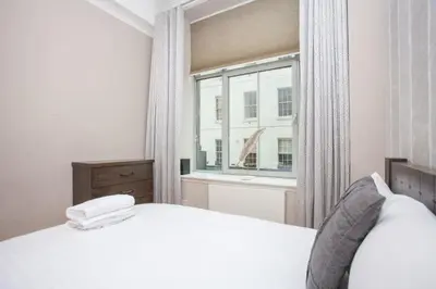 a bedroom with a white bed and a window at Stylish Merchant City Flat Glasgow in Glasgow