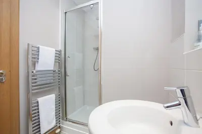 a bathroom with a shower and a toilet and a sink at Stylish Merchant City Flat Glasgow in Glasgow