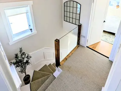 a staircase in a house with a mirror at Newly Refurbished 3 Bed House with 2-Sided Wood Burner and Garden in Edinburgh in Edinburgh