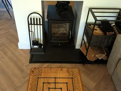 a living room with a fireplace and a rug at Newly Refurbished 3 Bed House with 2-Sided Wood Burner and Garden in Edinburgh in Edinburgh
