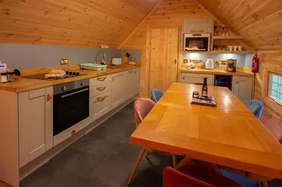 a kitchen with a wooden table in a cabin at Wildcat Lodge in Kilmichael Glassary