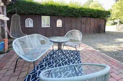 three chairs and a table and a table and chairs at Lily Wood Cottage outside Hurlford in Hurlford