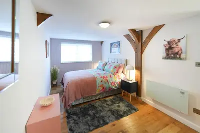 a bedroom with a bed and a tree at Lily Wood Cottage outside Hurlford in Hurlford