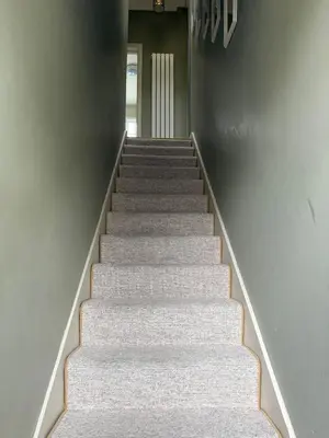a staircase with white carpeting and a stair case at Happy two bedrooms apartment in Moffat