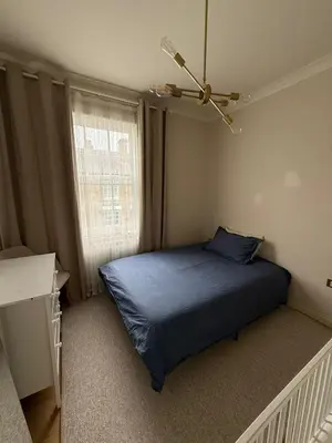 a bedroom with a blue bed and a window at Happy two bedrooms apartment in Moffat