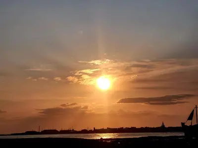 a sunset over the water with the sun in the sky at Ta'Pinu House and Spa in Horse Isle