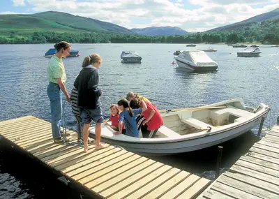 a group of people on a boat on a dock at Lochearnhead Loch Side in Lochearnhead
